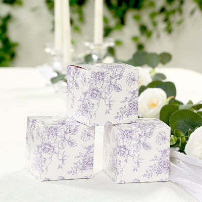 Decorative floral gift boxes arranged on a table with greenery.