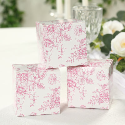 Pink floral gift boxes stacked elegantly on a table.