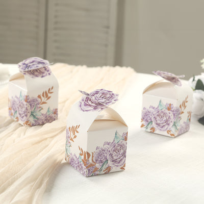 Floral gift boxes with purple roses on a soft fabric backdrop.