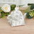 Floral-patterned tea kettle on a wooden surface with greenery.