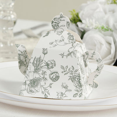 Floral-patterned teapot favor box on a plate.