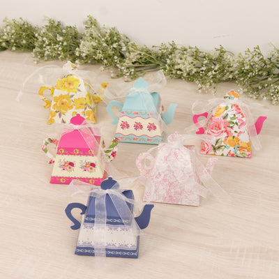 Colorful tea pot gift boxes in various floral designs with ribbons.
