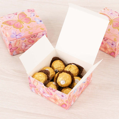 Open gift box filled with chocolate truffles and decorated with butterfly design.