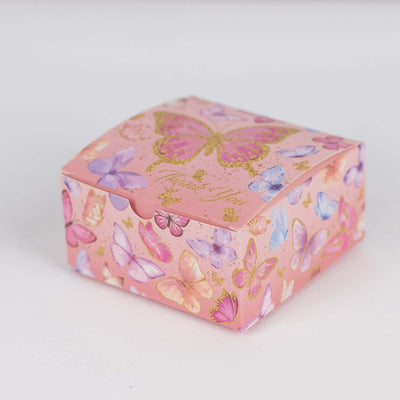 Pink gift box with butterfly design on a plain background.