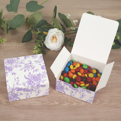 Colorful candy-filled box with floral design on wooden surface.
