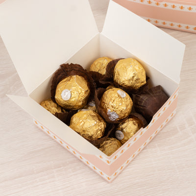 Box of golden chocolate truffles in a decorative gift box.
