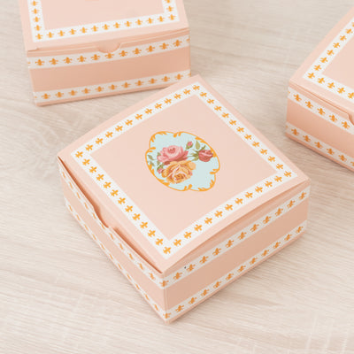 Decorative pink gift box with floral design and elegant borders.