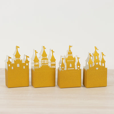 Set of four gold castle-themed gift boxes on a plain background.