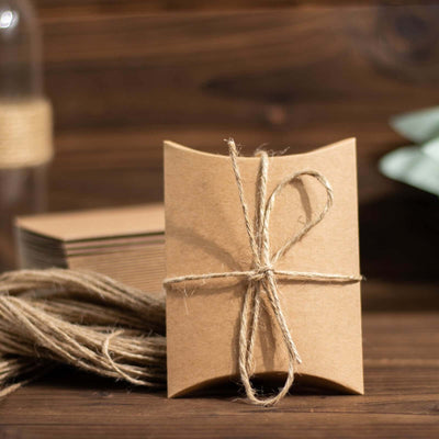 Brown kraft gift box tied with twine on a rustic wooden background.