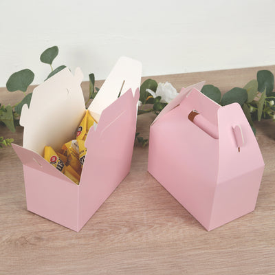 Pink takeaway boxes with snacks, styled with greenery.
