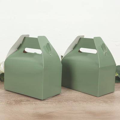 Green gift boxes with handles on a wooden surface.