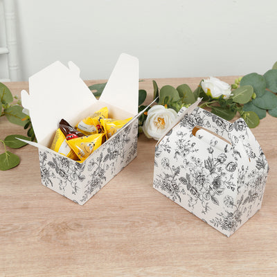Floral-patterned takeout boxes with snacks inside on a wooden surface.