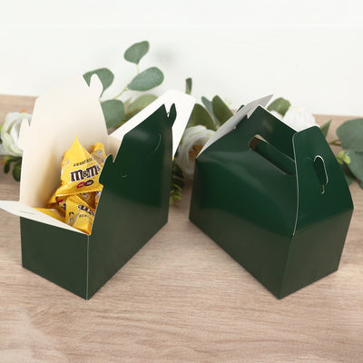 Green snack boxes filled with candies on a wooden surface.