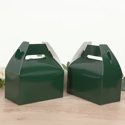 Green gift boxes with handles on a wooden surface.