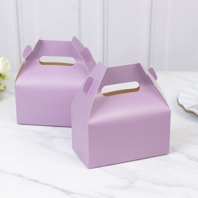 Purple gift boxes with handles on a marble surface.