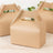Brown paper gable box with handle on a wooden surface.