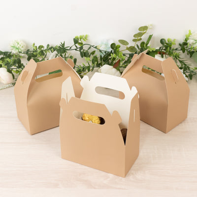 Three kraft paper takeout boxes on a wooden surface with greenery in the background.