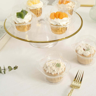 Assorted cupcakes in clear containers on a glass cake stand.