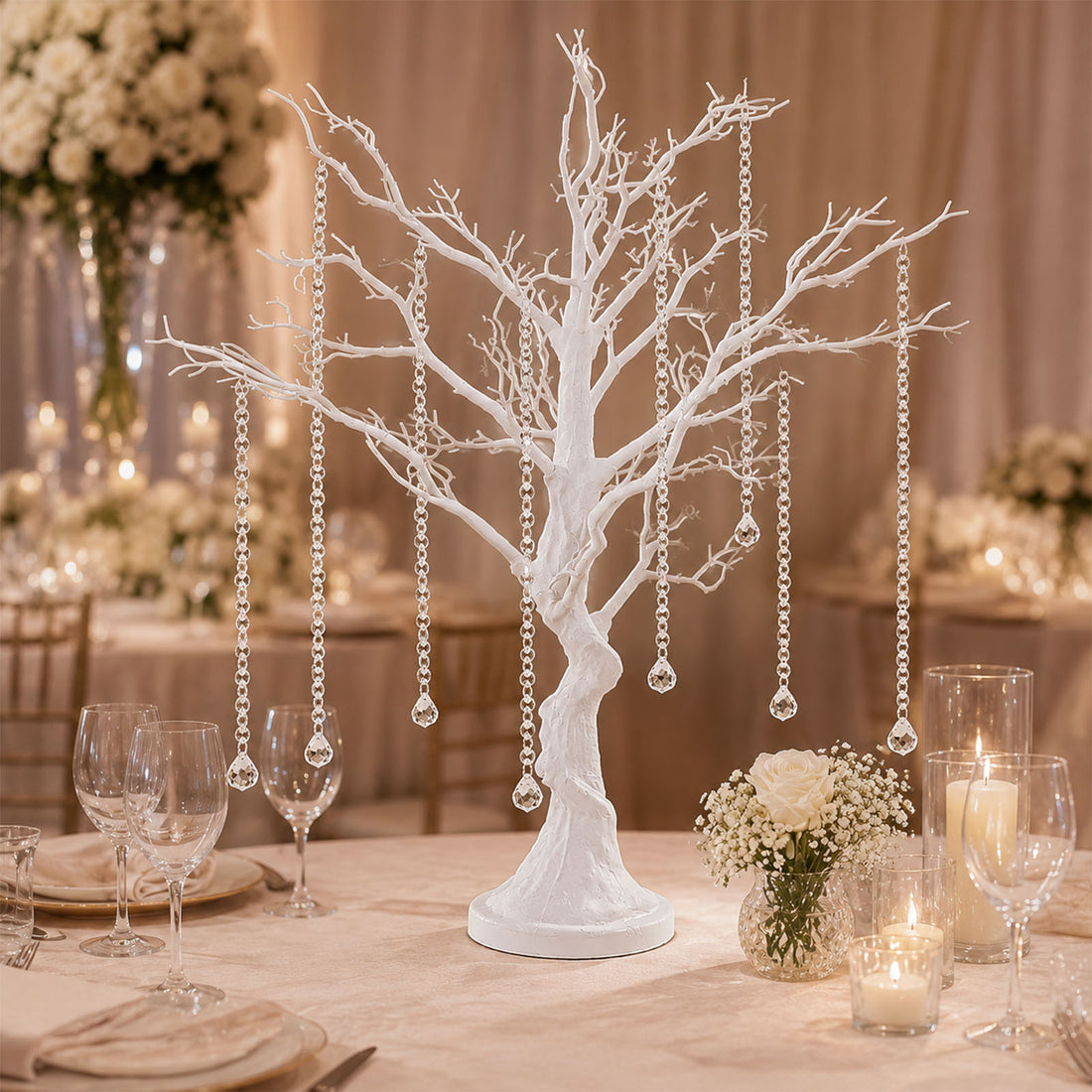 Elegant white tree centerpiece with hanging crystals at a wedding reception table