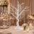 Elegant white tree centerpiece with hanging crystals at a wedding reception table