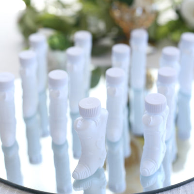 White cosmetic bottles arranged on a reflective surface.