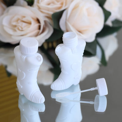 White boot-shaped bottles with lids and straws on a reflective surface.
