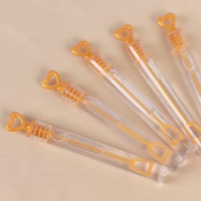 Heart-shaped bubble wands in clear plastic, arranged in a row.