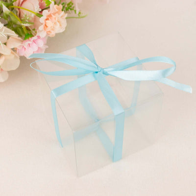 Clear gift box with blue ribbon and floral background.