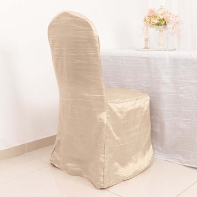 Beige chair cover draped on a simple chair in a decorated setting.