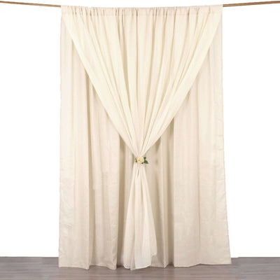 Cream-colored sheer curtain draped and tied with a floral accent