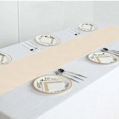 Elegant table setting with plates and utensils on white and beige tablecloths.