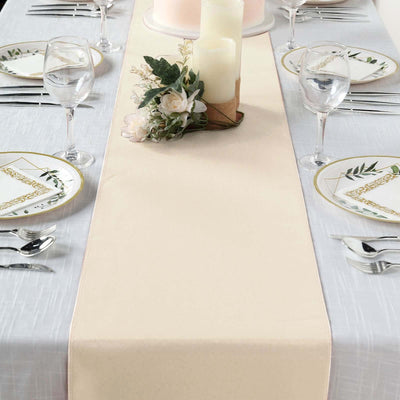 Beige table runner on a beautifully set dining table with floral decor.