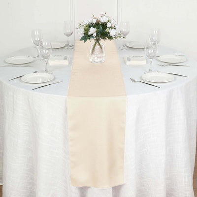 Elegant beige table runner on a white dining table set for a formal occasion.