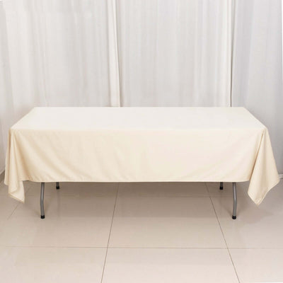 Beige tablecloth draped over a rectangular table in a studio setting.
