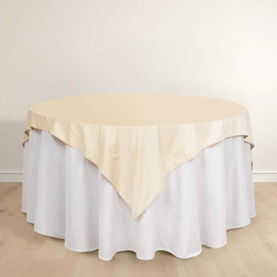Round table with beige and white tablecloth in a simple setting.