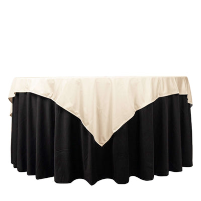 Round table with a black skirt and beige overlay