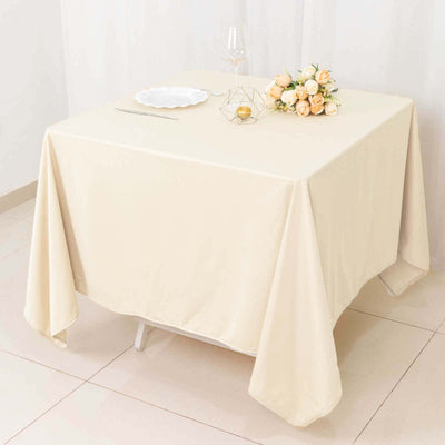 Cream tablecloth draped elegantly over a table with floral centerpiece.