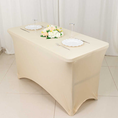 Elegant beige table with floral centerpiece and dinnerware set for two.