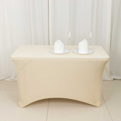 Beige table with two plates and glasses, set for dining.