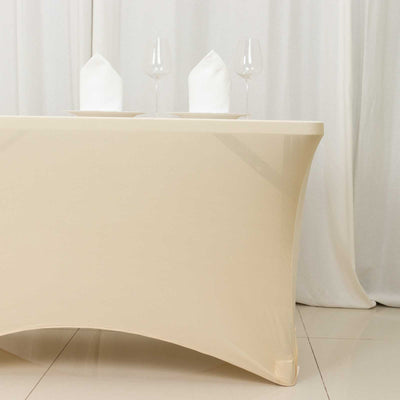 Elegant beige table with white napkins and glasses set for dining.
