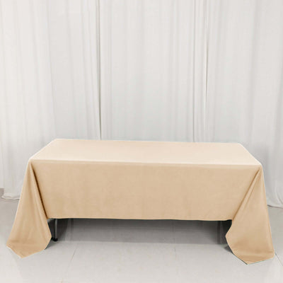 Beige tablecloth draped over a table in a studio setting.