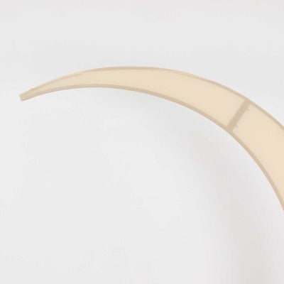 Curved beige plastic piece on a plain background