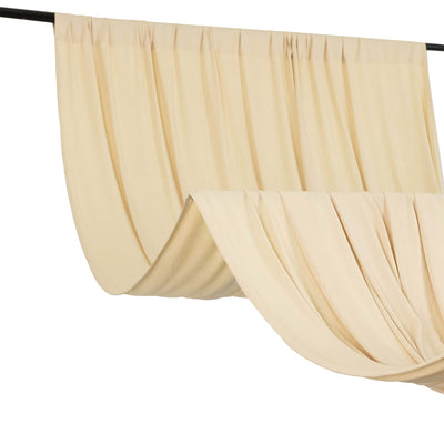 Flowing cream curtains draped elegantly on a black rod.