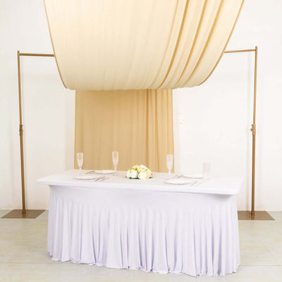 Elegant table setup with draped fabric and floral centerpiece.
