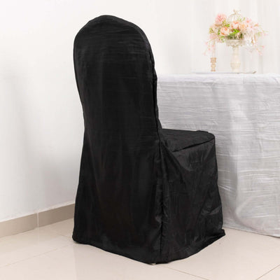 Black chair cover on a chair in a decorated dining setting.