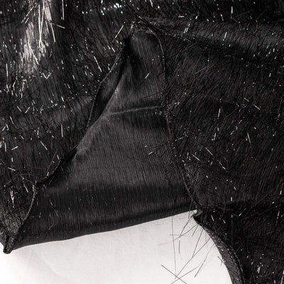 Black fabric with shimmering fibers, showcasing texture and detail.
