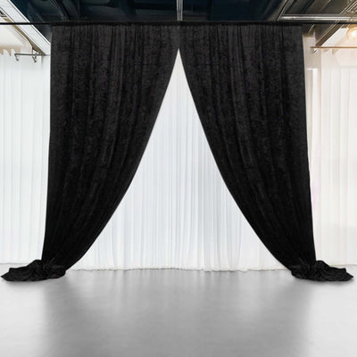Black velvet curtains draping over a white backdrop in a studio setting.