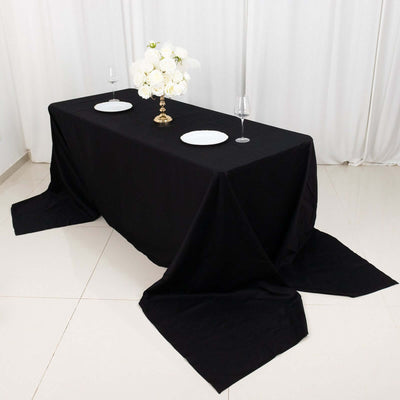 Elegant black tablecloth draped on a table with floral centerpiece and dinnerware.