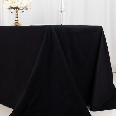 Black tablecloth draping elegantly over a table with a floral centerpiece.