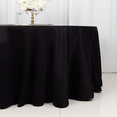 Black tablecloth elegantly draped on a table setting with floral centerpiece.